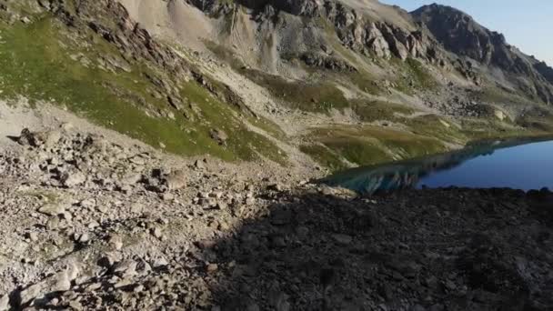Widok lotu wzdłuż brzegu alpejskiego jeziora z krystalicznie czystą wodą pitną. Chronione miejsca nietkniętej przyrody — Wideo stockowe