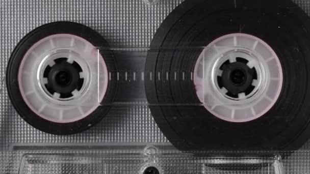 Close-up Una grabadora está reproduciendo un cassette de audio. Primer plano. Un cassette de audio vintage gira en una cinta adhesiva en blanco utilizada para grabar sonido en un reproductor de casetes retro. Grabación de conversaciones. — Vídeos de Stock