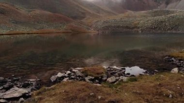 Alçak uçan alp gölü, bitki örtüsü olmadan. Akşamları toprağın kırmızı kayaları