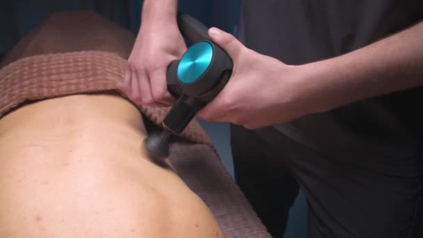 Bicí masáž zad zblízka. Profesionální práce jako perkusní masážní zařízení v masážní místnosti — Stock video