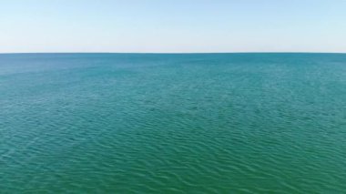 Okyanus yüzeyinde havadan uçuş. Açık denizde pürüzsüz bir ufuk. Deniz arkaplanı