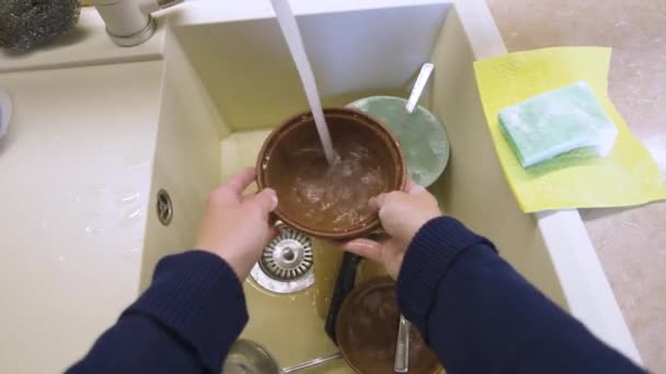 Close-up de uma jovem caucasiana lavando pratos em uma cozinha caseira — Vídeo de Stock