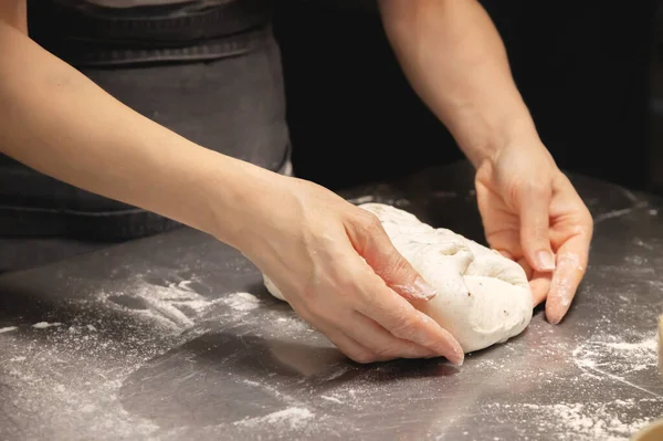 Las manos femeninas cumplen las acciones con el pan crudo. Masa antes de sumergirse en un horno de panadería — Foto de Stock
