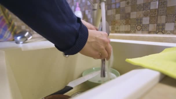 Primer plano de una joven caucásica lavando platos en una cocina casera — Vídeos de Stock