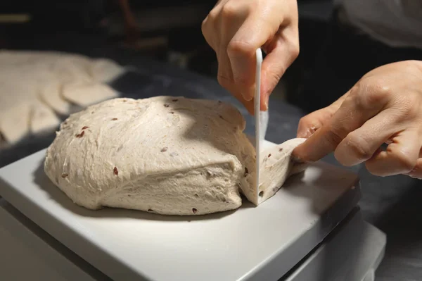 Las manos femeninas cumplen las acciones con el pan crudo. Masa antes de sumergirse en un horno de panadería — Foto de Stock