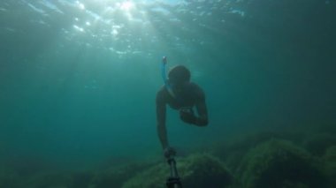 Bir adam elinde bir pusula tutar ve suyun altındayken yön arar. Oryantasyon konsepti esprisi. Bir yol bulma kavramı. Bir turist su altında yol almak için pusula kullanır.