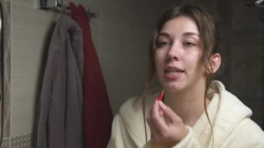 Genç beyaz kadın interdental alanları temizlemek için küçük bir fırça kullanıyor. Düzeltici hizalama ve lastik bant kullanımı. Profesyonel Ağız Temizliği.