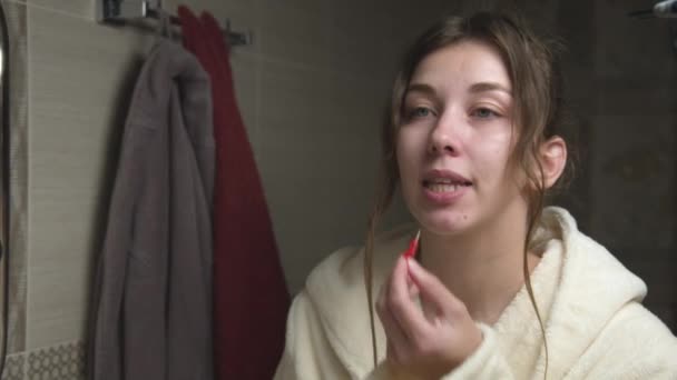 若い白人女性は歯間空間をきれいにするために小さなブラシを使用しています 修正アライナーとゴムバンドの使用 口腔衛生専門 — ストック動画