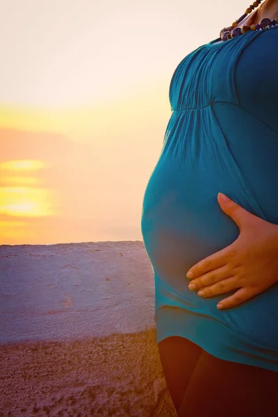 Schwangerer Bauch im Sonnenuntergang — Stockfoto