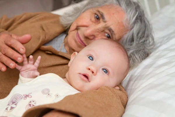 Urgroßmutter legt sich mit Baby hin — Stockfoto