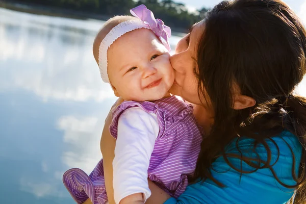 Mom Kissing Baby Daughter By Lake — Stock Photo, Image