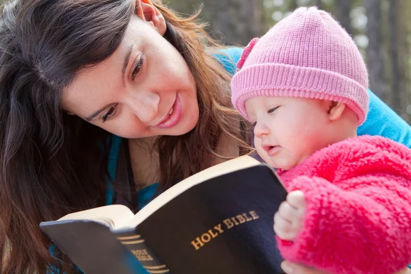 엄마와 아기 딸 성경 읽기 스톡 사진