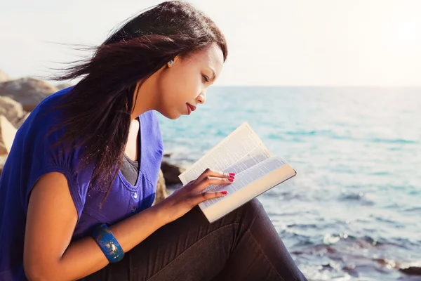 Giovane ragazza studiando la sua Bibbia dal mare — Foto Stock