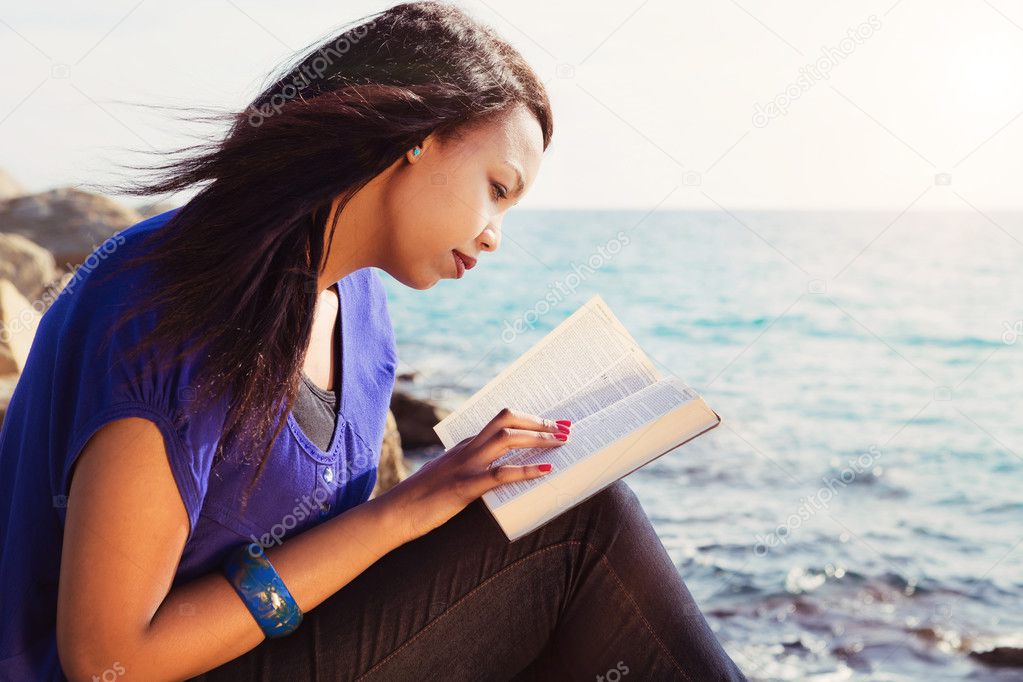 Young Girl Studying Her Bible By The Sea