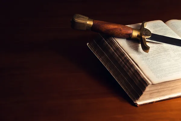 Antigua Biblia abierta con espada Imagen De Stock