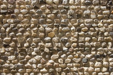 Rough, highly textured old stone block wall from Greece clipart
