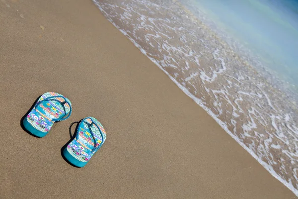 Pantoufles de plage bleues sur la plage de sable avec espace de copie pour le texte, somme — Photo