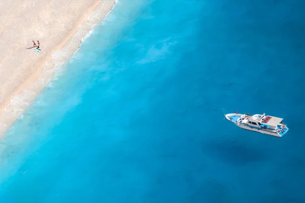 Boat on the ionic sea, a romantic couple at the beach — Stock Photo, Image