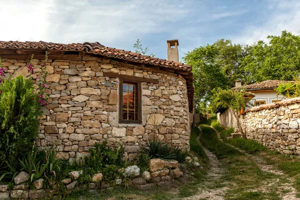 En stenmur och ett gammalt hus från arbanasi, bulgaria. — Stockfoto