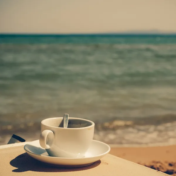 Cup of coffee at the beach - vintage coaster — Stock Photo, Image