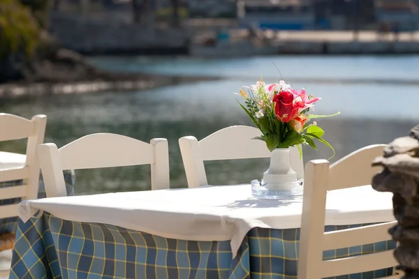 Praia grega com mesa azul tradicional e cadeiras — Fotografia de Stock