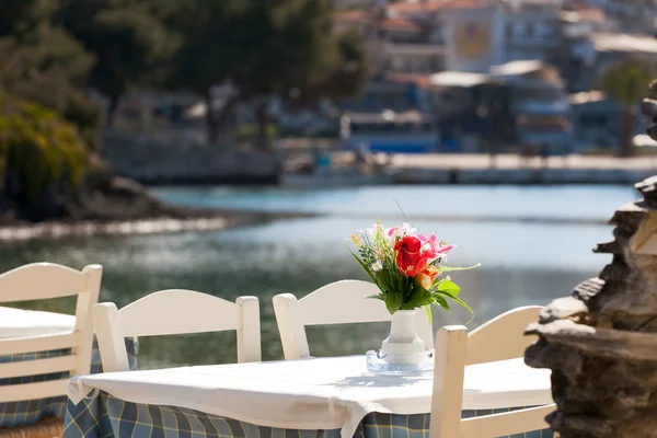 Playa griega con mesa y sillas azules tradicionales — Foto de Stock