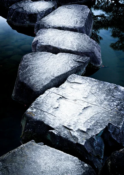 Каменный путь через спокойный пруд — стоковое фото