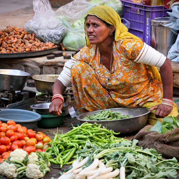 Unidentified woman sells vegetables at fair — Stock Photo, Image
