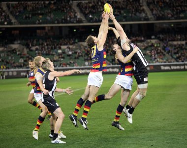 MELBOURNE - AUGUST 21: Adelaide's Scott Stevens (centre) and Collingwood's Chris Dawes (r) stretch for a mark during Collingwood's win over Adelaide - August 21, 2010 in Melbourne, Australia clipart