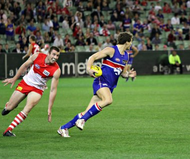 MELBOURNE - SEPTEMBER 12: Will minson burns off Darren Jolly in the AFL second semi final clipart