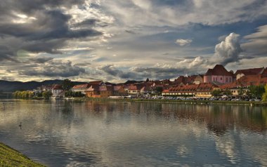 Maribor, Slovenya. Maribor, Slovenya 'nın şehir manzarası güzel yaz günbatımında Drava Nehri' nin yansımasıyla.
