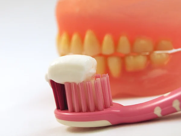 Pasta de dentes branca na escova de dentes e dentes amarelos — Fotografia de Stock