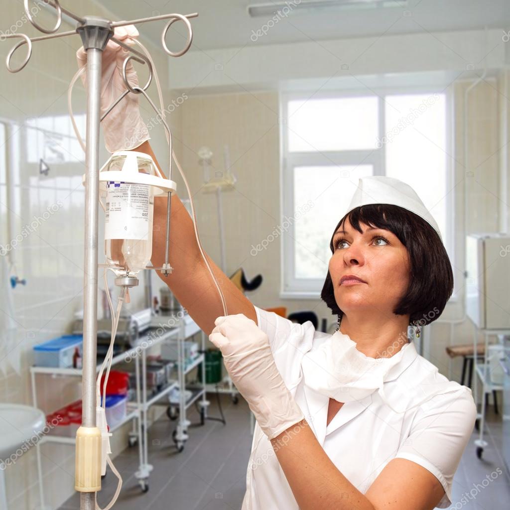 Beautiful nurse preparing to hold intravenous drip medication