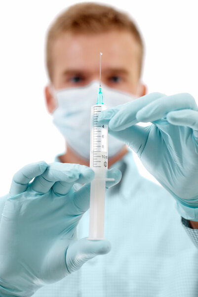 Young medical doctor with syringe in hands.