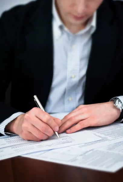 Les hommes d'affaires remplissant des documents avec un stylo . — Photo