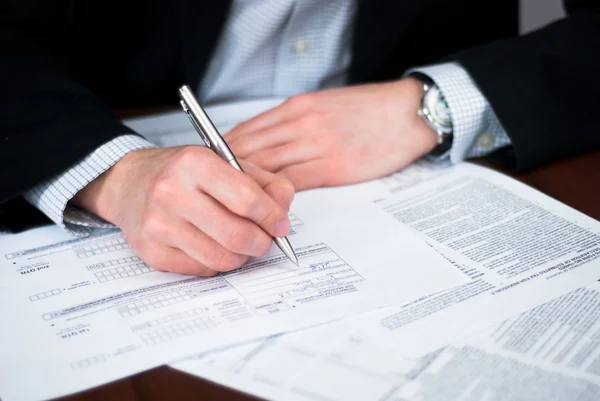 Hombres de negocios llenando algunos documentos . —  Fotos de Stock