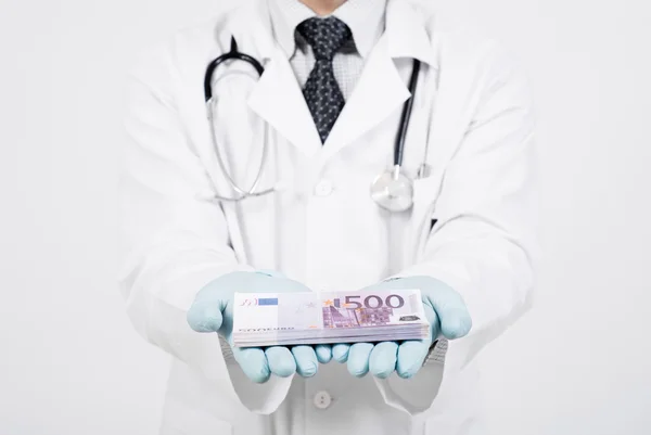 Doctor and money for the operation — Stock Photo, Image