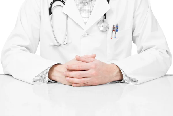 Lekarz z stetoskop i ręce na stole — Zdjęcie stockowe