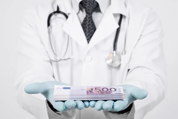 Doctor and money for the operation — Stock Photo, Image