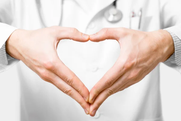 หมอหนุ่มที่มีมือรูปหัวใจบนพื้นหลังสีขาว — ภาพถ่ายสต็อก