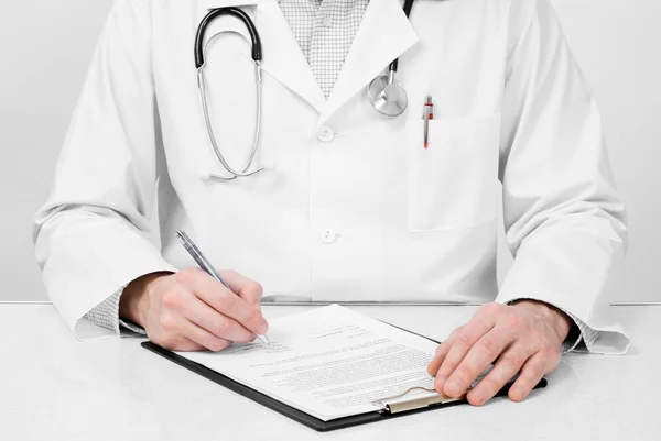 Doctor with stethoscope making notes — Stock Photo, Image