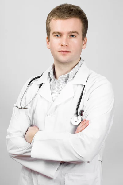 Portrait of happy young doctor isolated on grey background Stock Picture