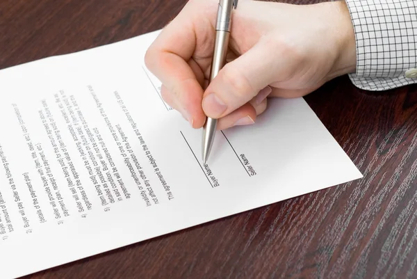 Подписание контракта бизнесменом — стоковое фото