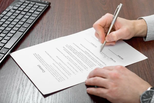 Подписание контракта бизнесменом — стоковое фото
