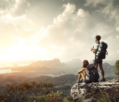 Hikers with backpacks enjoying valley view clipart