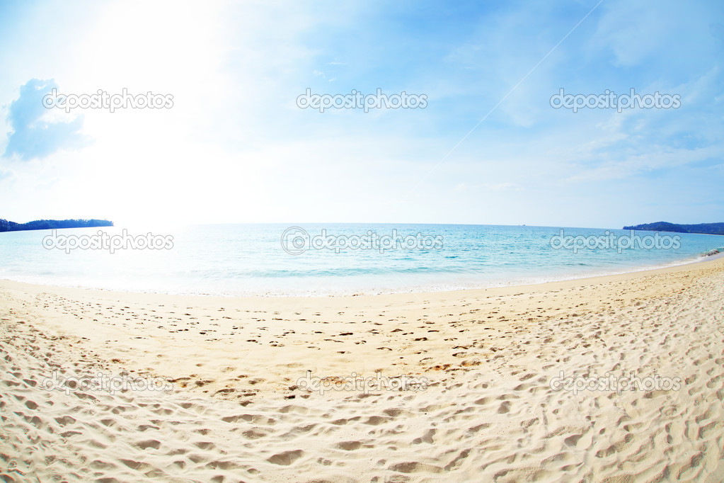 Tropical beach with white sand and calm sea with blue cloudy sky