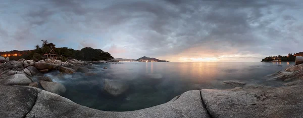 岩の多い海岸線とモーションのパノラマ夕暮れの海の表面をぼやけています。プーケット、タイ — ストック写真