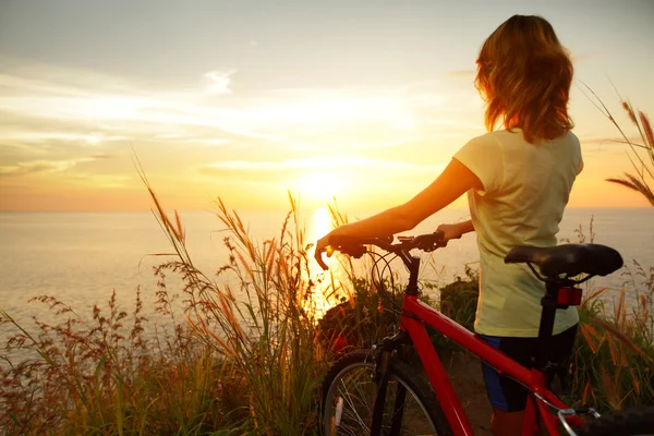 Young lady standing with bicycle — Stockfoto