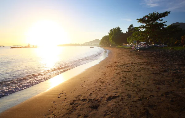 Východ slunce nad písečnou pláž poblíž rybářské vesnice pemuteran, bali, Indonésie — Stock fotografie