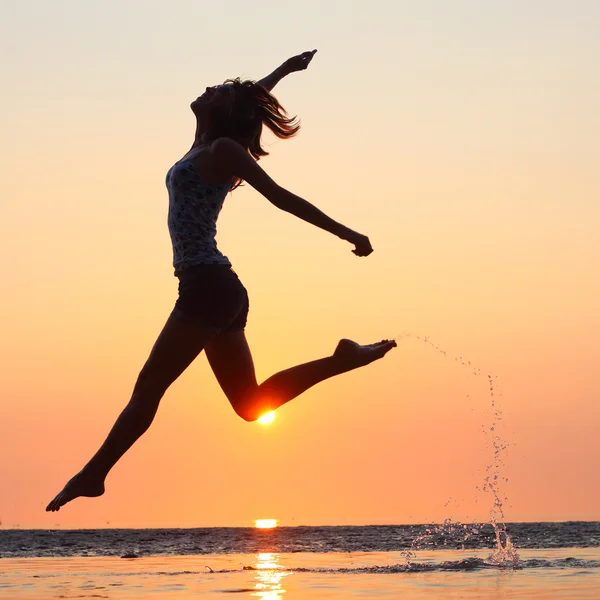 Señora corriendo y saltando en una playa — Foto de Stock